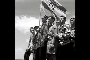 Jewish survivors stand on the deck of a refugee immigration ship at Haifa port, during the British Mandate of Palestine, in what would later become the state of Israel. (Zoltan Kluger/GPO via Getty Images)